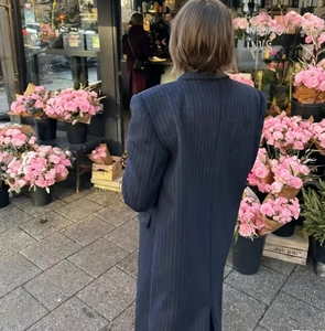 Street style shot of a slim-fit navy blue striped long coat with textured wool fabric