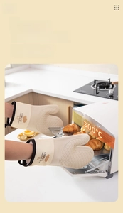 Detail of 300°C heat-resistant silicone oven mitts holding fresh croissants from an oven