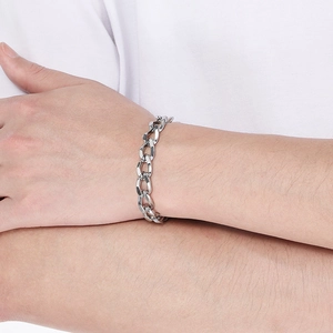Gros plan d'un bracelet gourmette unisexe en acier argenté porté au poignet