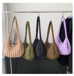 Detailed shot showing five colors of quilted puffer bags on a metal display stand