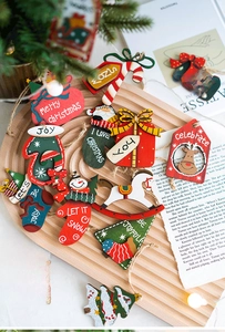 Close-up of wooden Christmas ornaments with festive patterns on a rustic wooden tray