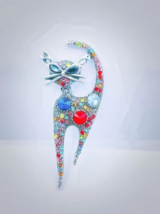 Detailed close-up of a silver cat brooch featuring colorful rhinestones on a white background
