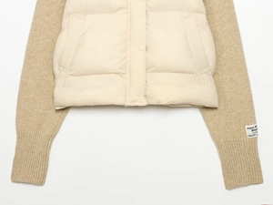 Detail of knit patchwork jacket with ribbed cuffs and branded textile label on the sleeve