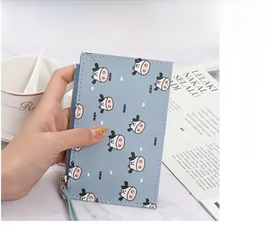 Slim light blue coin purse with cute cow print and zipper closure held by hand