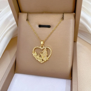 Detail of gold heart pendant with crystal butterfly inlay in a velvet jewelry box
