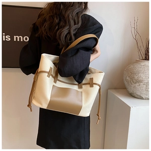 Detailansicht der Canvas-Tasche mit braunem Lederbesatz und seitlichem Kordelzug