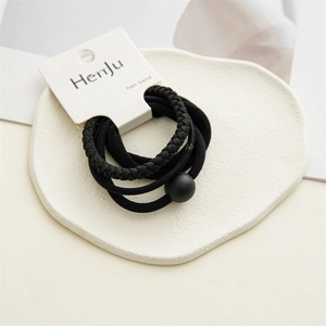 Detail of 4-piece black elastic hair ties set with beads on a white display card