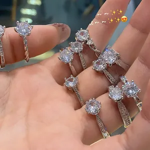 Close-up of multiple silver diamond rings with six-prong settings and various designs