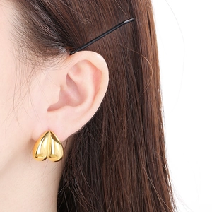 Gros plan d'une femme portant une boucle d'oreille en forme de cœur doré au fini poli