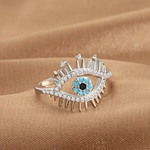 Anello aperto occhio del diavolo argento con pietre blu su sfondo di raso