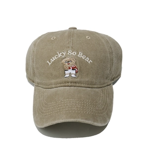 Close-up of cute cartoon bear embroidery on khaki cotton washed baseball cap