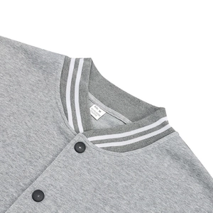 Détail du col en tricot gris à rayures blanches avec fermeture à bouton-pression