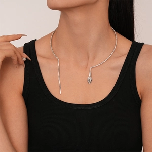 Gros plan d'un collier ras du cou serpent en strass argenté porté par un mannequin femme