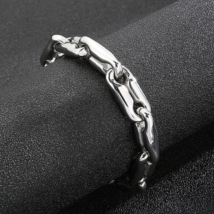 Close-up of silver punk chain bracelet with oval links on textured black display stand