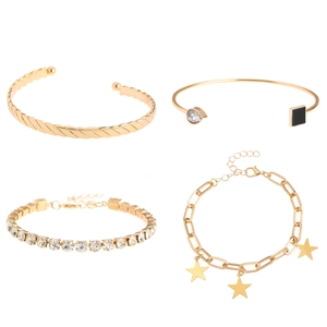 Detail van gouden armbandenset met gedraaide manchet, tennisketting en sterhangers
