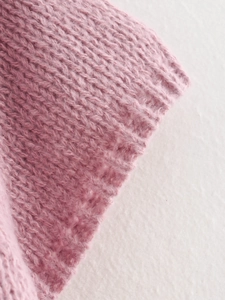 Close-up of pink knit fabric showing detailed ribbed texture and soft material quality