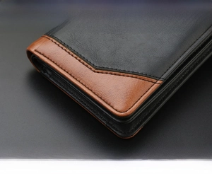 Close-up of dual-tone leather wallet corner with precise stitching and refined texture