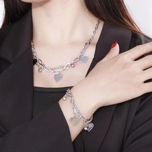 Silver heart and bead double-layer chain necklace and bracelet set on a female model