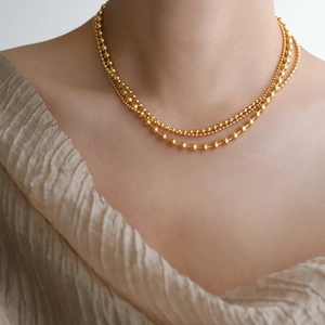Three-layer gold beaded chain necklace with elegant layered design in polished titanium steel