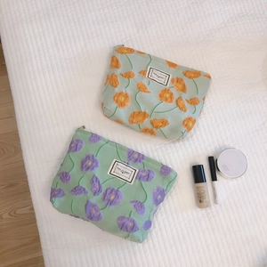 Textured floral cosmetic bag with lily-of-the-valley embroidery and zipper closure