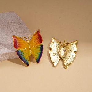 Detail showing the front enamel butterfly and textured golden back of the earring