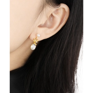 Elegant gold drop earrings with white pearl and oval crystal stud on female model