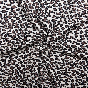 Vue détaillée du tissu doux à imprimé léopard avec motifs à taches brunes et noires