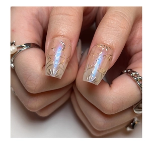 Detailed macro of long square press-on nails with blue aurora finish and gold celestial art