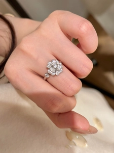Macro detail of camellia flower ring with sparkling zircon stones in a silver finish