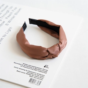 Close-up of brown satin twisted headband showing silky texture and elegant knot design