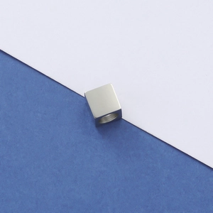 Macro shot of square silver stainless steel spacer bead with threaded hole for DIY jewelry