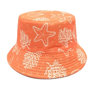 Close-up of orange bucket hat featuring white starfish, coral, and seashell prints