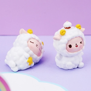 Close-up of cute resin sheep figurines for car interiors and desk decor on cloud base