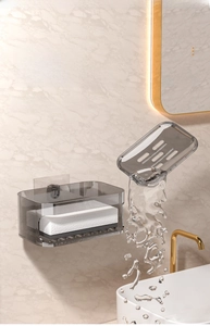 Detail of wall-mounted double-layer soap box with drainage in a cream bathroom