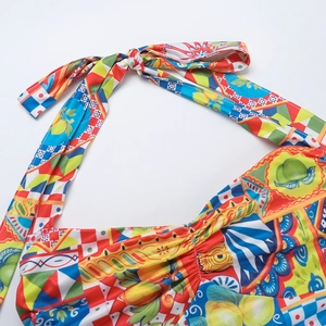 Close-up of vibrant Mediterranean lemon print fabric with halter neck knot detail