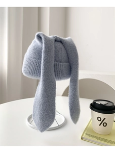 Detail of light blue knit hat featuring plush long bunny ears and soft mink texture