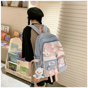 Detail view of colorful school backpack with cute rabbit pins and transparent pocket