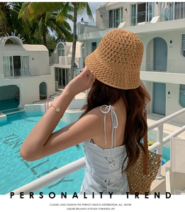 Gros plan d'un chapeau cloche en paille marron avec une robe d'été à fleurs bleues