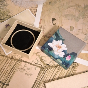 Silver bangle with a vintage lotus painted jewelry gift box on calligraphy background
