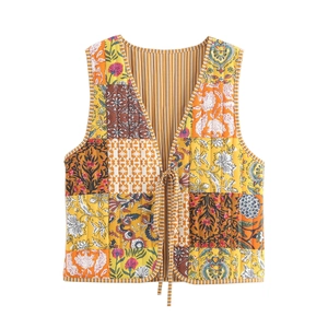 Detail view of quilted floral vest featuring colorful patchwork and double ribbon ties