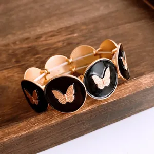 Vintage style elastic bracelet with black enamel round charms and gold butterfly motifs