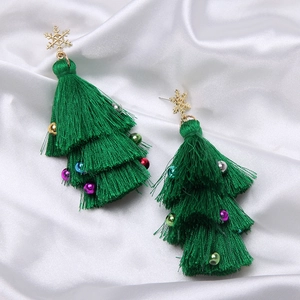 Detailed view of Christmas tree tassel earrings with colorful beads on white silk