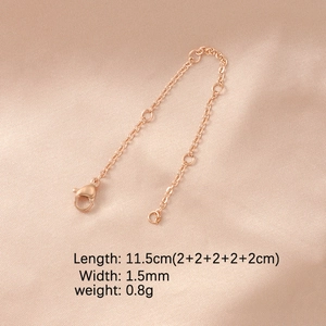 Detailed view of rose gold extension chain with lobster clasp on pink silk texture fabric