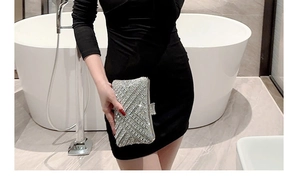 Close-up of sparkling silver rhinestone evening clutch bag held by a model in a luxury setting