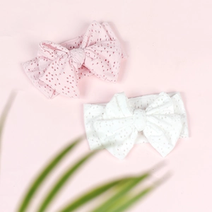 Pink and white hollow knit baby headbands featuring a large knot bow design