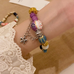 Colorful ceramic beaded bracelet featuring a lucky cat charm and small metal flower