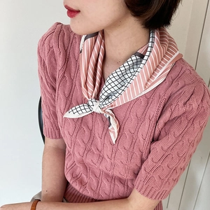 Detailed view of pink and white striped silk scarf tied stylishly around the neck