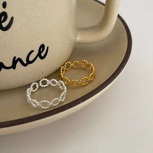 Minimalist 925 silver hollow beaded rings in gold and silver finish on a ceramic tray