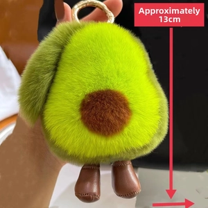 Close-up of soft avocado plush keychain with fuzzy green fur and brown leather feet