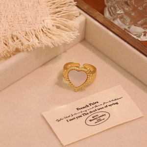 Close-up of a vintage heart ring with white shell inlay in a velvet jewelry box